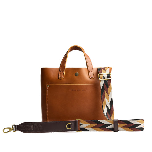 Golden Dusk | Patterned fabric and leather strap attached to leather purse on a white background