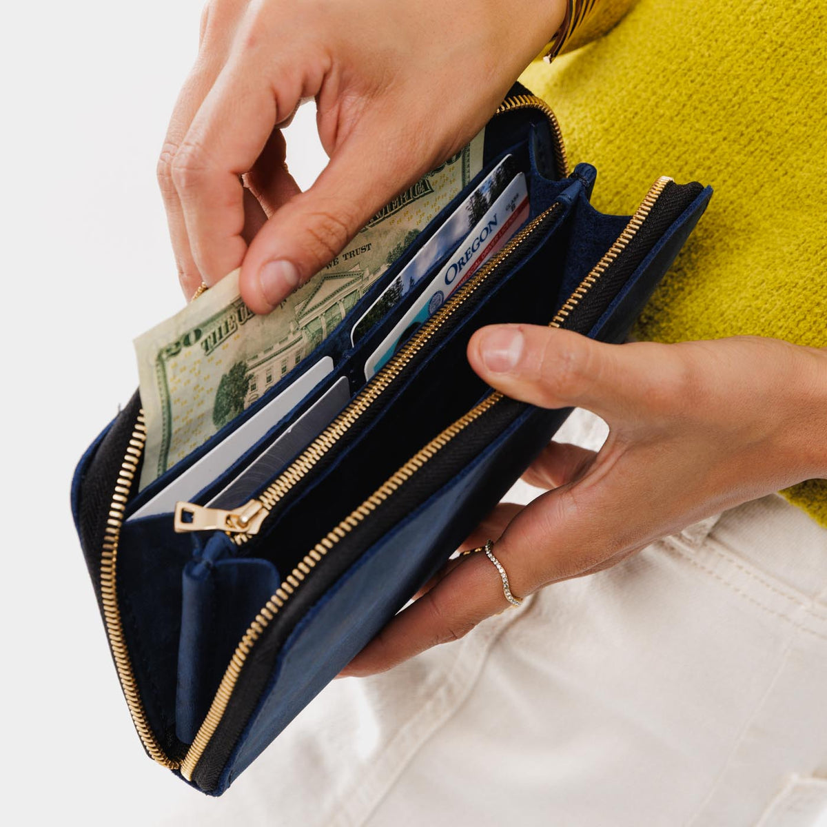 Deep Water | Model holding large accordion leather wallet with zipper open