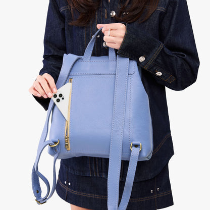 Aster | Model wearing a leather backpack on a white background