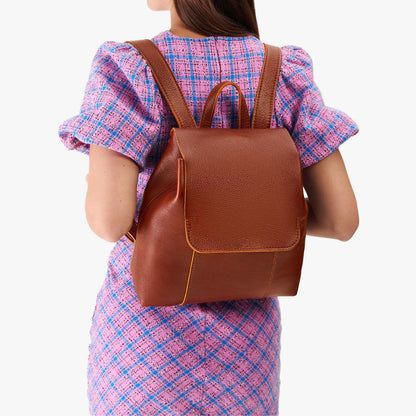 Nutmeg | Model wearing a leather backpack on a white background