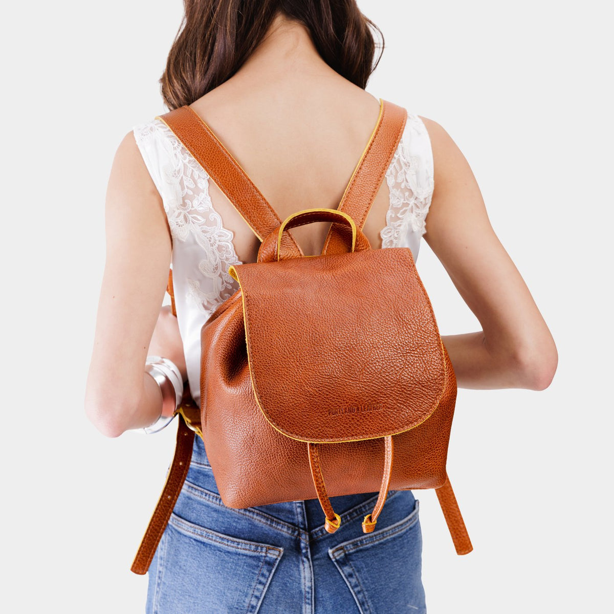 Sienna | Pebbled leather drawstring backpack being worn by a person.