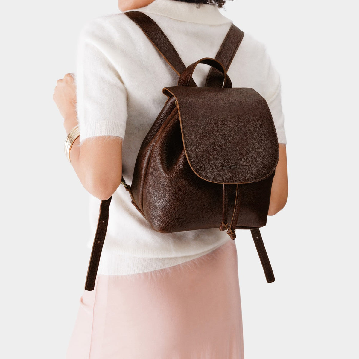 Coldbrew | Pebbled leather drawstring backpack being worn by a person.