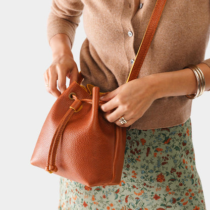 Sienna*Small | Model holding slouchy crossbody bag with drawstring closure