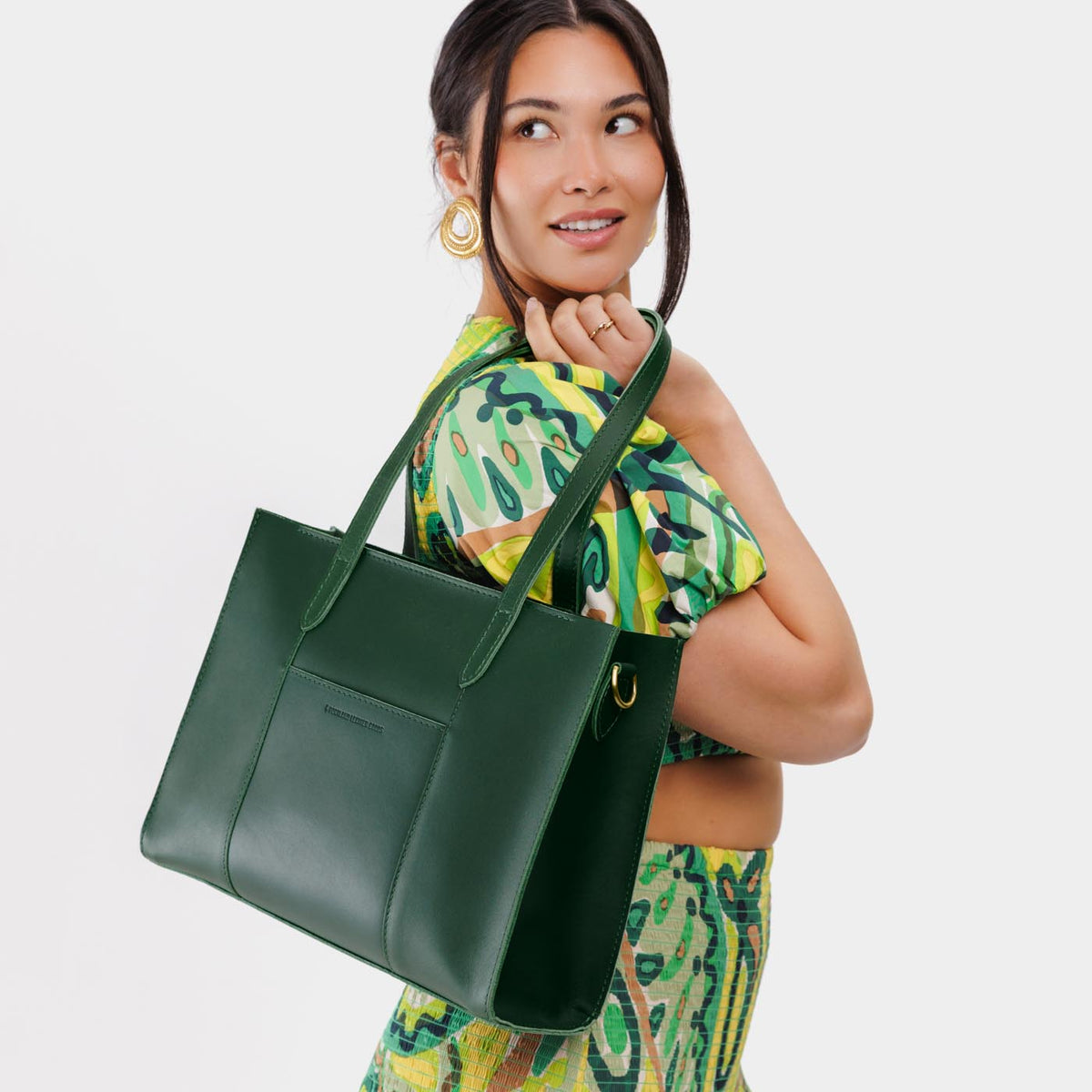 Aruba*East/West | Model wearing structured wide tote bag with overlapping panels and crossbody strap
