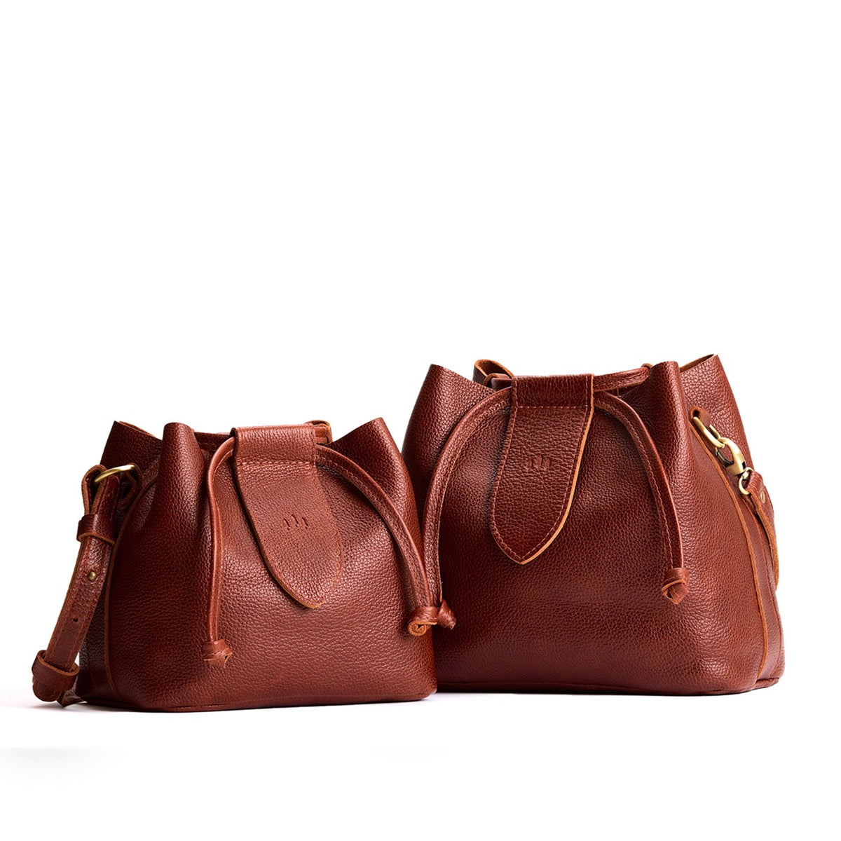 Nutmeg | Small and large symmetrical leather bags with leather drawstring closure and adjustable shoulder strap
