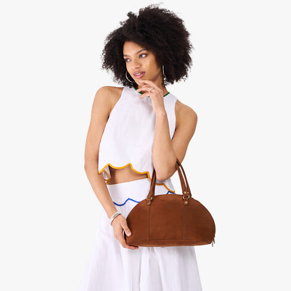 Wildwood*Small | Model holding a half circle crossbody bag with handles and removable crossbody strap