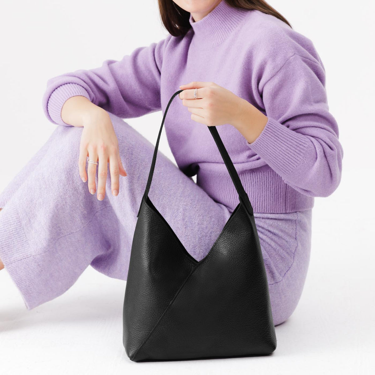 Pebbled--black*Large | Model holding mid-size shoulder bag with magnetic snap closure