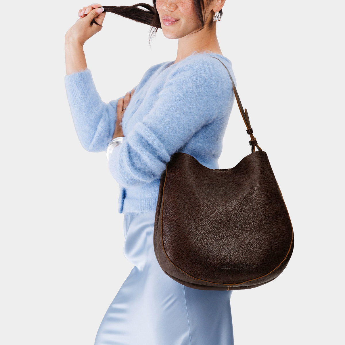 Coldbrew*Large | Woman wearing rounded shoulder bag with adjustable strap on a white background