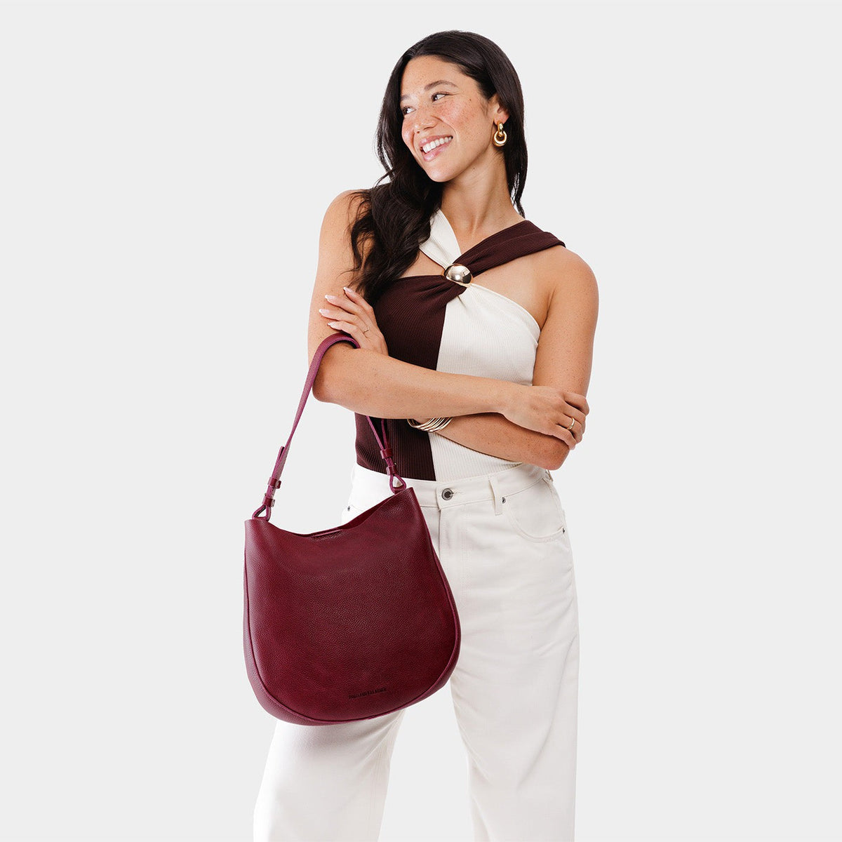 Orchid*Large | Woman wearing rounded shoulder bag with adjustable strap on a white background