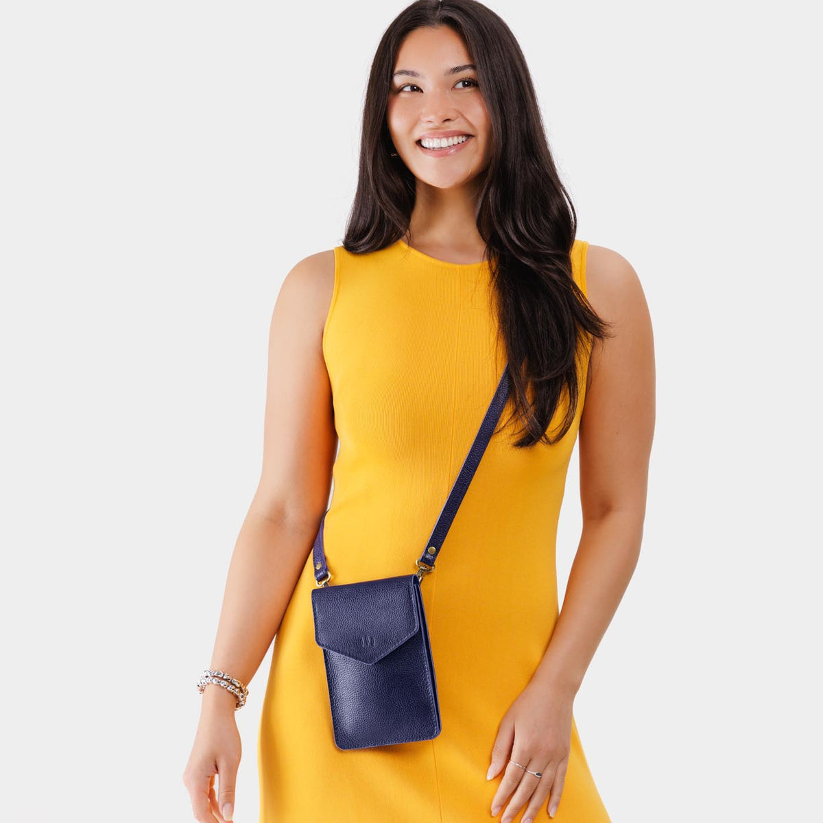 Cobalt | Model wearing slim, phone-shaped crossbody purse with magnetic closure