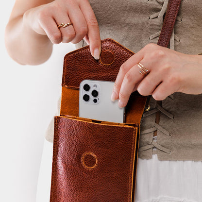 Nutmeg | Model wearing slim, phone-shaped crossbody purse with magnetic closure