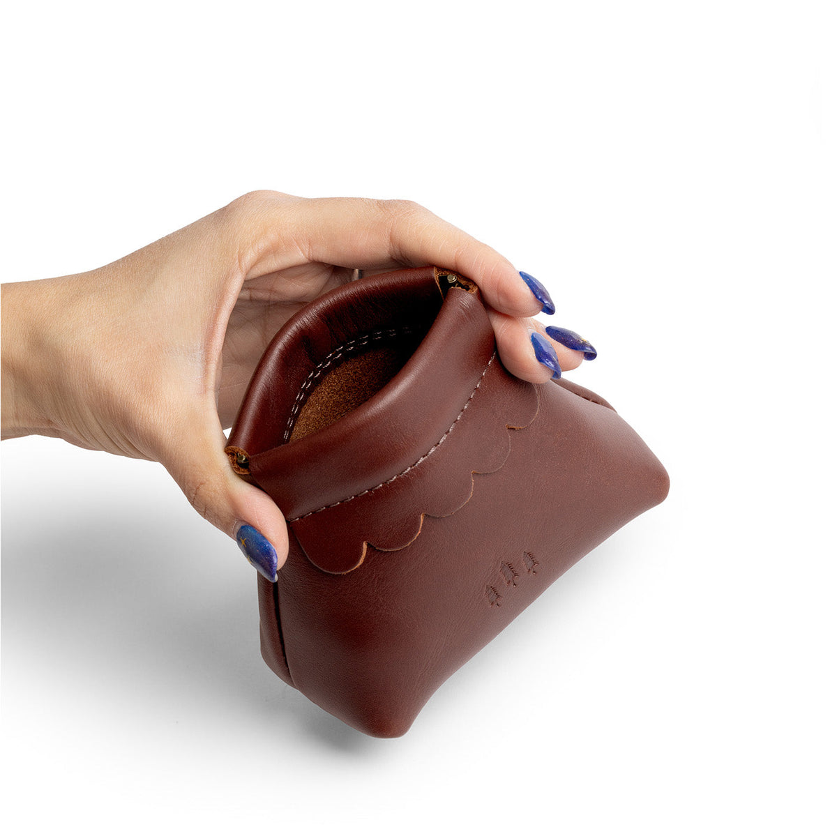 Cognac | Hand holding leather coin pouch with scalloped edge and three Portland leather tree emblems open