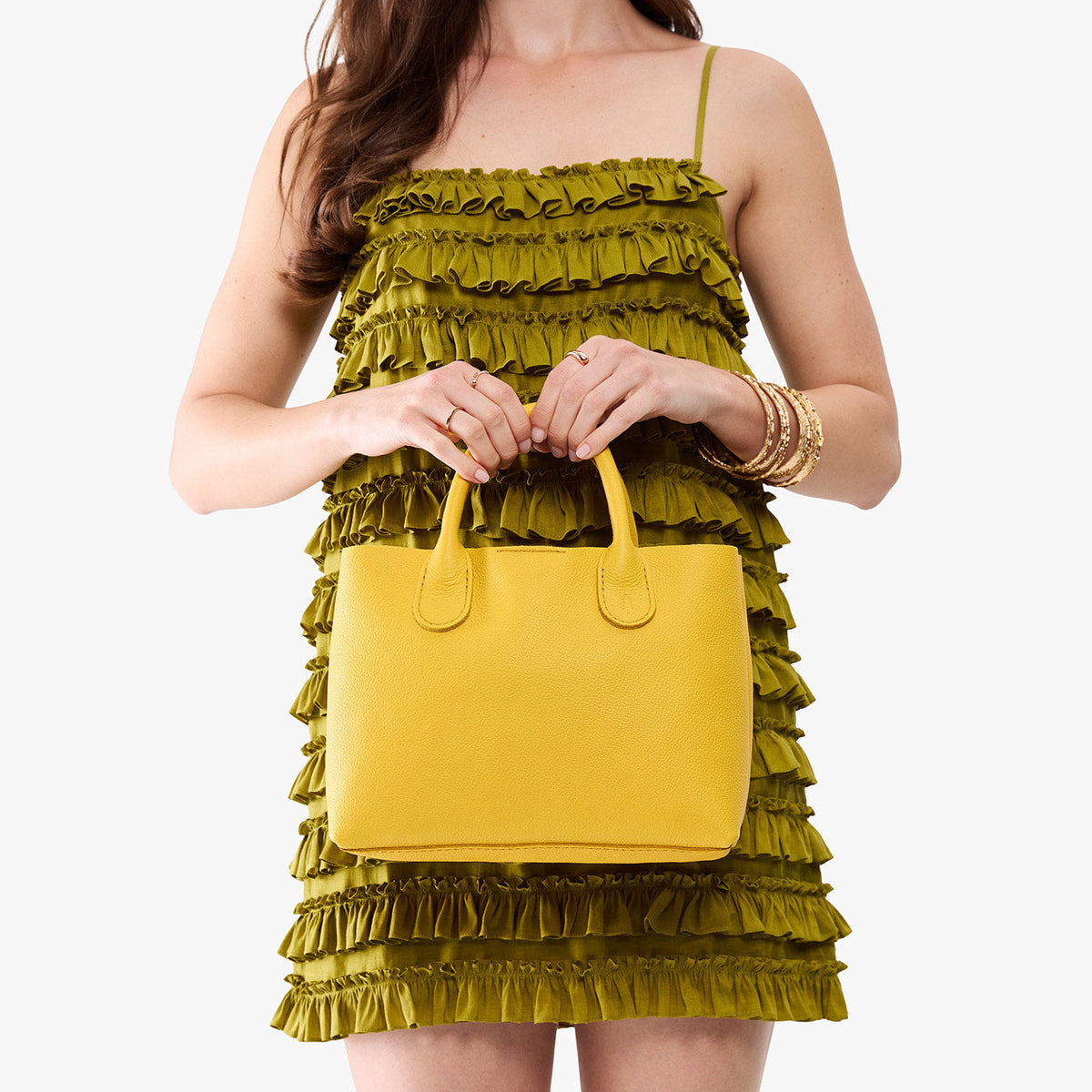 Canary*Large | Model holding a mid-size tote purse with structured leather handles and crossbody strap