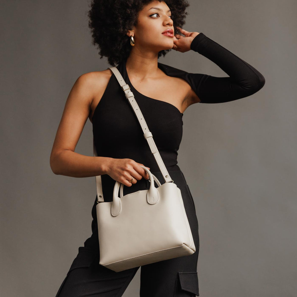 Bone*Large | Model holding mid-size tote purse with structured leather handles and crossbody strap