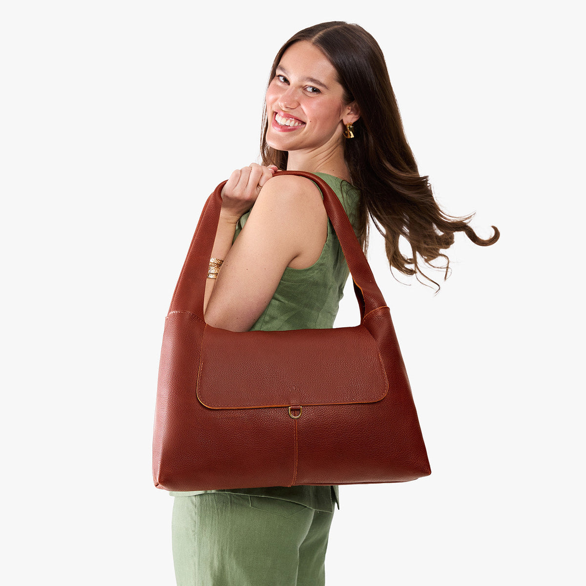 Nutmeg*Large | A model holding a slouchy triangle shaped shoulder bag with a flap