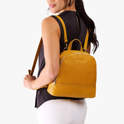 Sunshine | Model wearing leather backpack with debossed Portland Leather logo on front