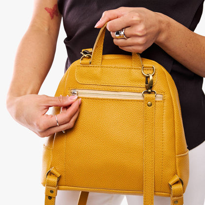Sunshine | Model holding leather backpack with back zipper pocket