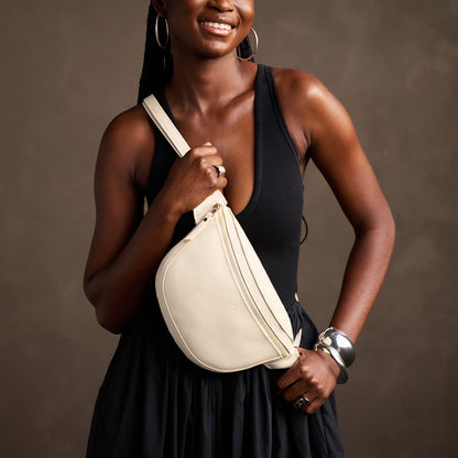 Pebbled Bone | Model wearing a sling bag with front zipper