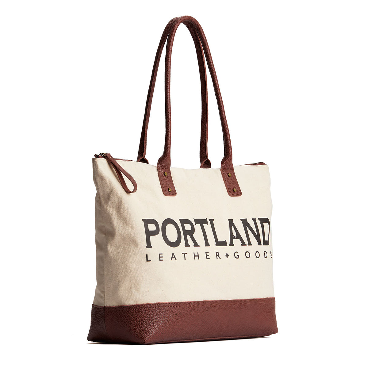 Canvas tote with zipper, leather bottom, and leather handles on a white background