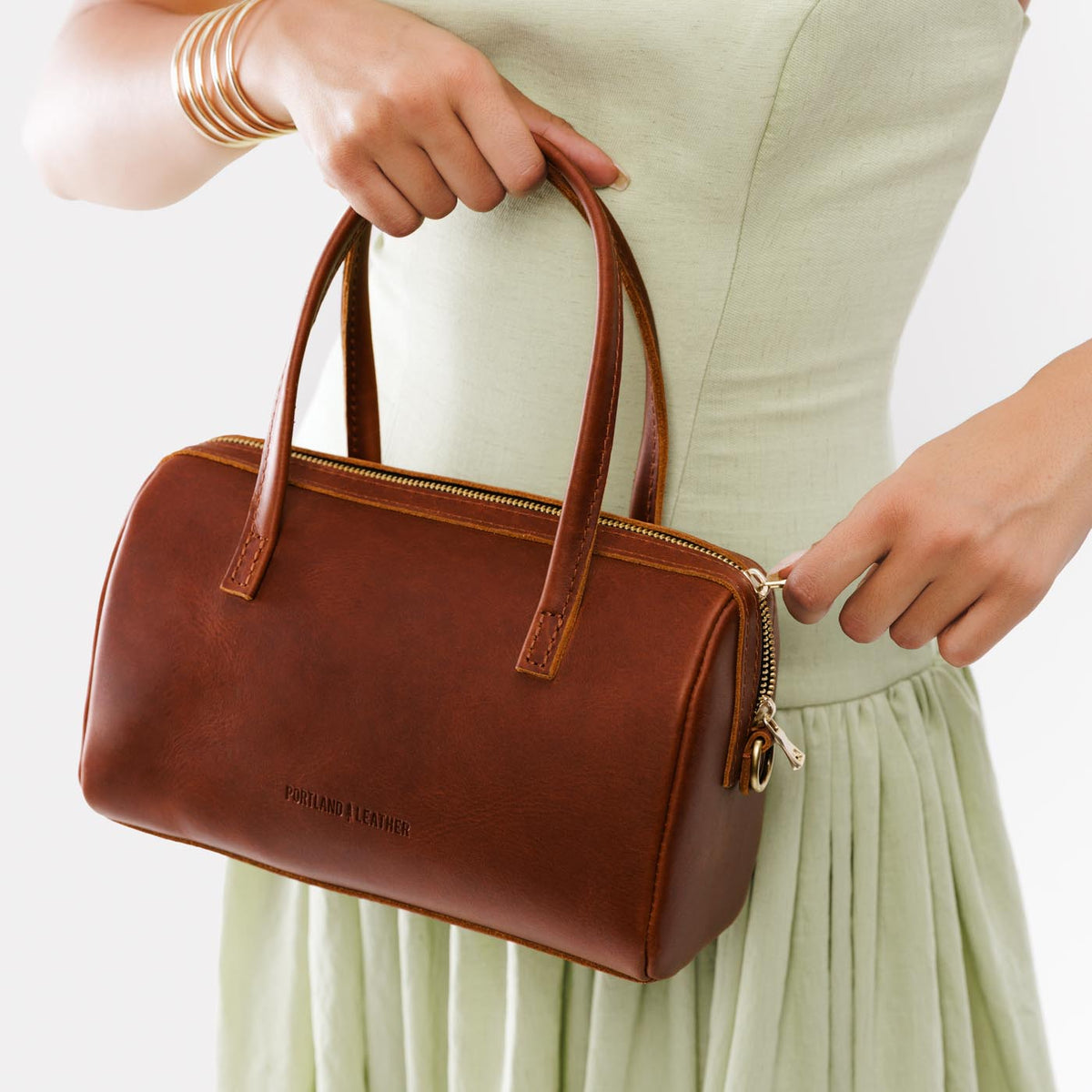Chestnut*Large | Model wearing mini duffle shaped handbag with crossbody strap