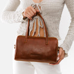 Nutmeg*Large | Model wearing mini duffle shaped handbag with crossbody strap