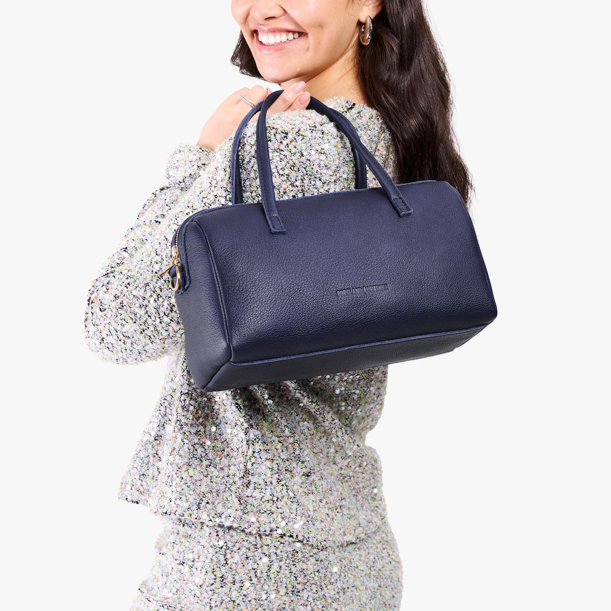 Cobalt*Oversized | Model holding mini duffle shaped handbag with crossbody strap