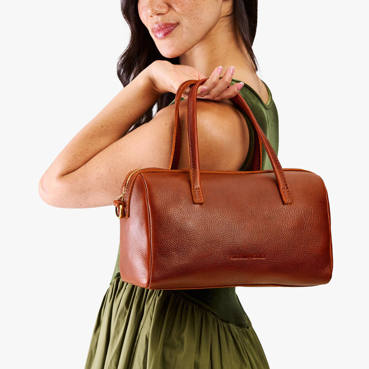 Nutmeg*Oversized | Model holding mini duffle shaped handbag with crossbody strap