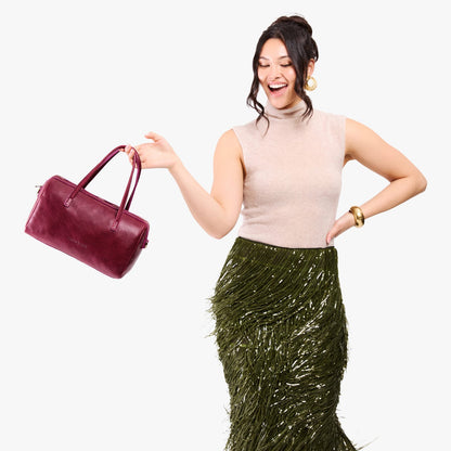Orchid*Oversized | Model holding mini duffle shaped handbag with crossbody strap