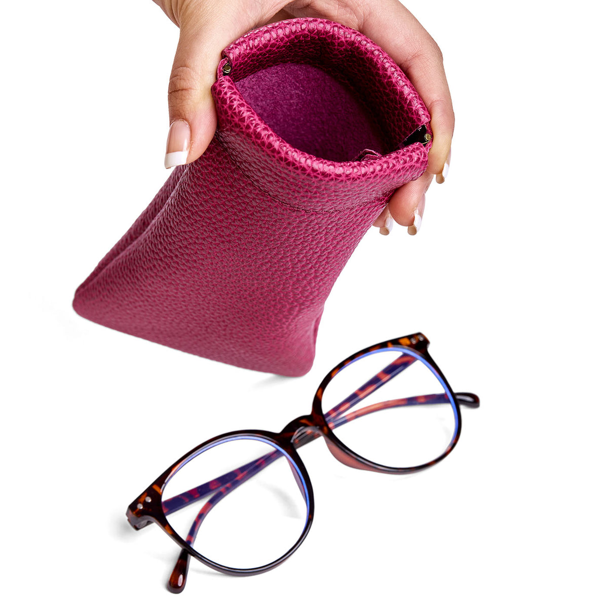 Cosmo | Model hand holding open leather glasses case with hidden metal spring closure above a pair of glasses