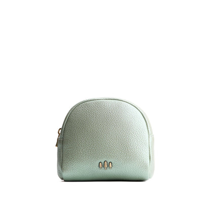 Beetle | Curved top leather pouch with zipper opening, flat base, and three metal tree emblems in front